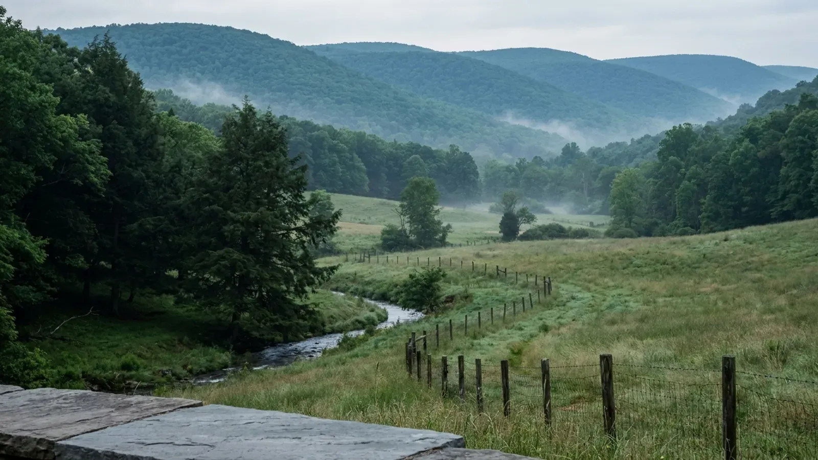 A green farm valley in Western Maryland with long, even forested ridges running parallel into the distance.